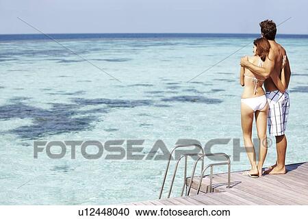 Stock Image - Couple at swimming pool. Fotosearch