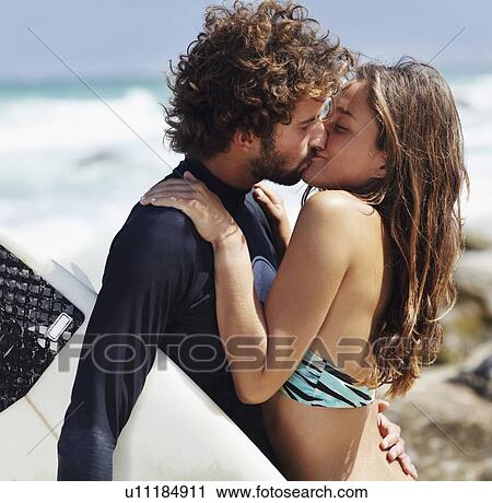 Stock Image - Couple kissing on beach. Fotosearch