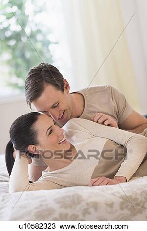 Stock Image - Couple lying on bed. Fotosearch