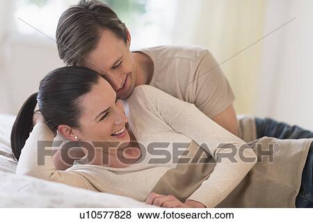 Couple lying on bed View Large Photo Image Stock Photo - Couple lying on bed. Fotosearch