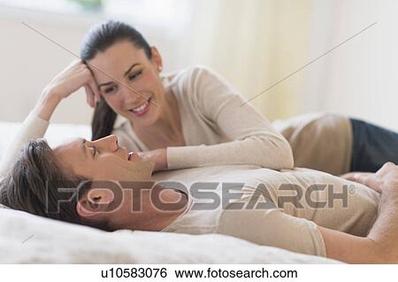 Stock Photograph - Couple lying on bed. Fotosearch