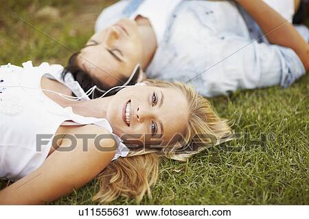 Stock Image - Couple lying on grass. Fotosearch