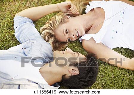 Stock Photo - Couple lying on grass. Fotosearch