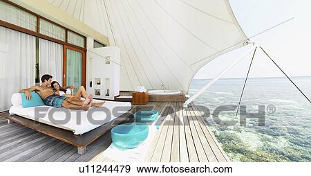 Couple relaxing on deck by sea View Large Photo Image Stock Photo - Couple relaxing on deck by sea. Fotosearch