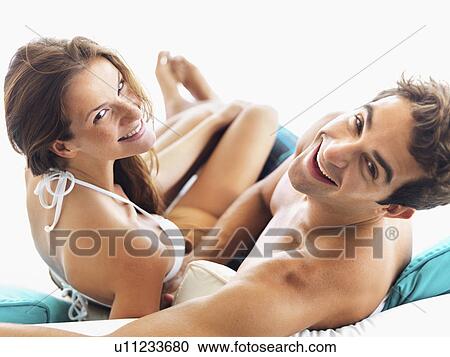Stock Image - Couple relaxing on sofa together. Fotosearch