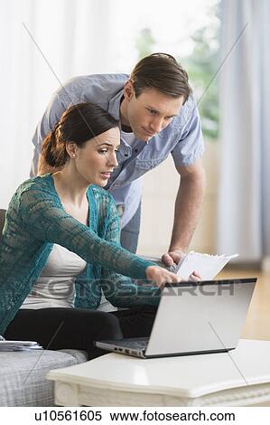 Couple using laptop together to pay bills View Large Photo Image Stock Photography - Couple using laptop together to pay bills. Fotosearch