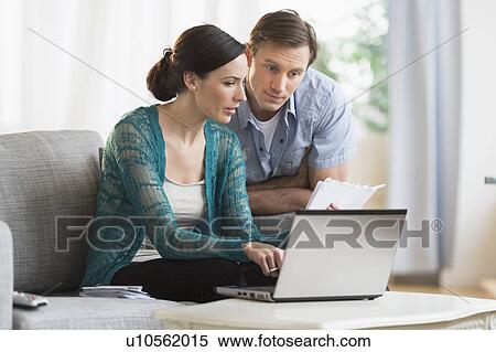 Couple using laptop together to pay bills View Large Photo Image Stock Photography - Couple using laptop together to pay bills. Fotosearch