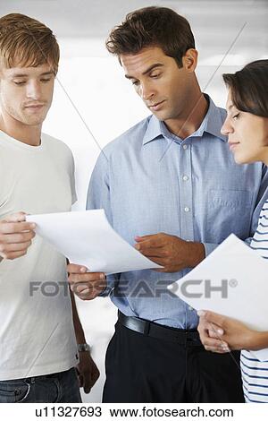 Coworkers doing paperwork View Large Photo Image Stock Image - Coworkers doing paperwork. Fotosearch