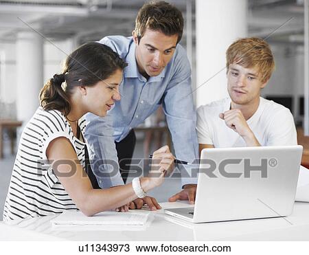 Coworkers looking at laptop View Large Photo Image Stock Image - Coworkers looking at laptop . Fotosearch