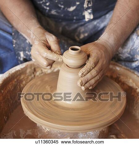 Elevated view of hands working with clay on potter's wheel View Large Photo Image Stock Photography - Elevated view of hands working with clay on potter's wheel. Fotosearch