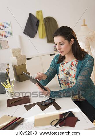 Stock Photo - Fashion designer using digital tablet. Fotosearch