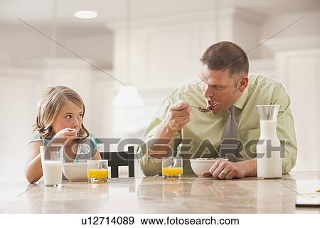 Father and daughter (6-7) eating breakfast View Large Photo Image Stock Photo - Father and daughter (6-7) eating breakfast. Fotosearch