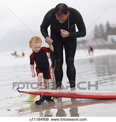 Father and his son (2-3) on beach by surfboard View Large Photo Image Stock Photo - Father and his son (2-3) on beach by surfboard. Fotosearch