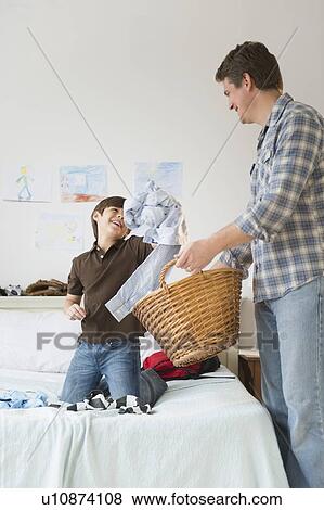 Father and son (8-9) collecting dirty clothes View Large Photo Image Stock Photo - Father and son (8-9) collecting dirty clothes. Fotosearch