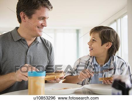 Father and son (8-9) eating lunch View Large Photo Image Stock Photograph - Father and son (8-9) eating lunch. Fotosearch