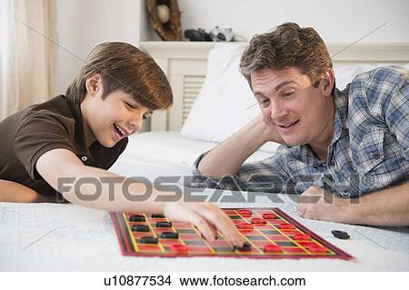 Picture - Father and son (8-9) playing checkers. Fotosearch