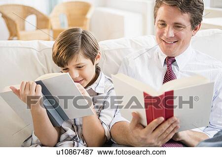 Stock Photo - Father and son (8-9) reading books. Fotosearch