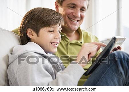 Father and son (8-9) using digital tablet View Large Photo Image Stock Photography - Father and son (8-9) using digital tablet. Fotosearch