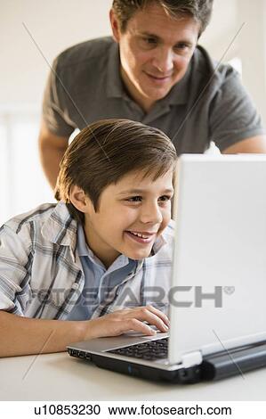 Father and son (8-9) using laptop View Large Photo Image Stock Image - Father and son (8-9) using laptop. Fotosearch
