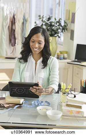 Stock Image - Female entrepreneur using digital tablet. Fotosearch