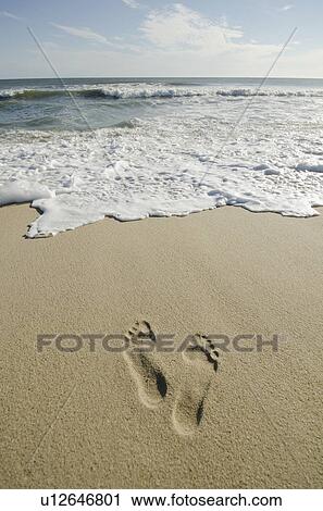 Stock Image - Footprints on sandy beach. Fotosearch