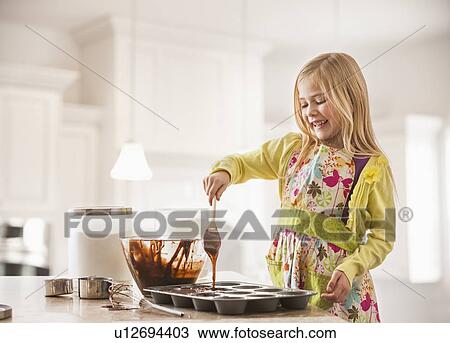 Girl (6-7) baking cupcakes View Large Photo Image Stock Image - Girl (6-7) baking cupcakes. Fotosearch