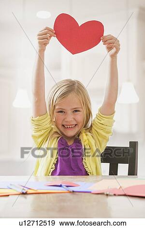 Girl (6-7) holding red paper heart View Large Photo Image Stock Photo - Girl (6-7) holding red paper heart. Fotosearch