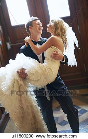 Stock Image - Groom carrying bride. Fotosearch