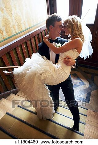 Stock Photo - Groom carrying bride. Fotosearch