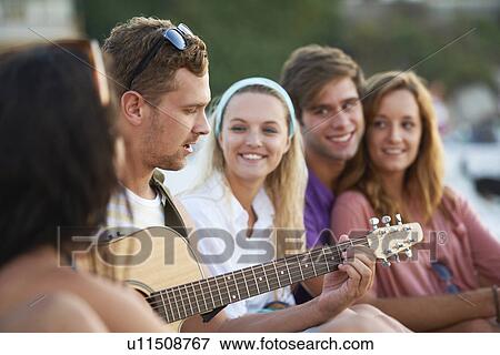 Group of friends relaxing at beach View Large Photo Image Stock Photo - Group of friends relaxing at beach. Fotosearch