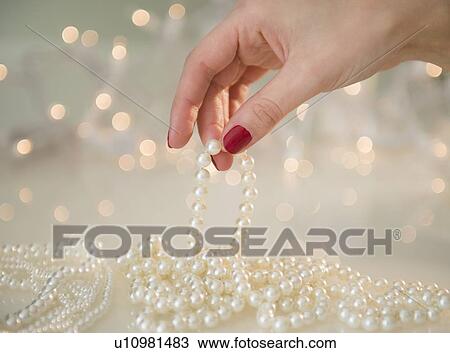 Hand holding pearl necklace View Large Photo Image Stock Image - Hand holding pearl necklace. Fotosearch