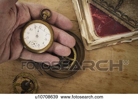 Stock Photo - Hands holding antique clock and gears. Fotosearch