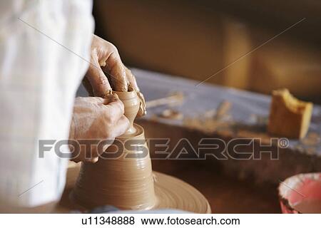 Stock Photo - Hands working with clay on potter's wheel. Fotosearch