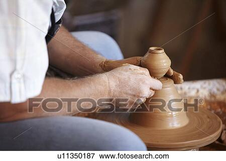 Hands working with clay on potter's wheel View Large Photo Image Stock Photo - Hands working with clay on potter's wheel. Fotosearch