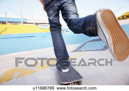 Stock Photo - Legs on moving skateboard. Fotosearch