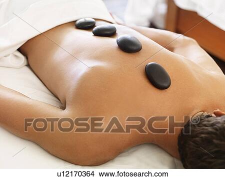 Man getting hot stone therapy in spa View Large Photo Image Picture - Man getting hot stone therapy in spa. Fotosearch