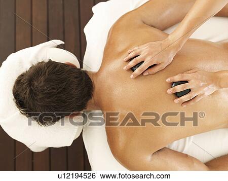 Man getting stone massage in spa View Large Photo Image Stock Photograph - Man getting stone massage in spa. Fotosearch