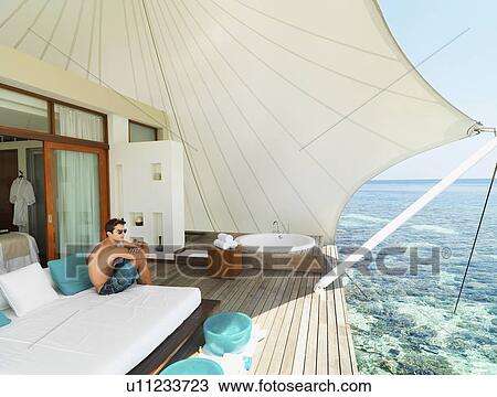 Man sitting on deck relaxing View Large Photo Image Stock Image - Man sitting on deck relaxing. Fotosearch