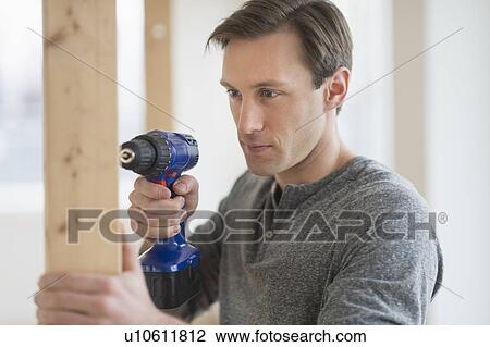 Man using hand drill View Large Photo Image Stock Image - Man using hand drill. Fotosearch