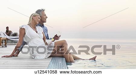 Mature couple sitting by seashore View Large Photo Image Stock Photo - Mature couple sitting by seashore. Fotosearch