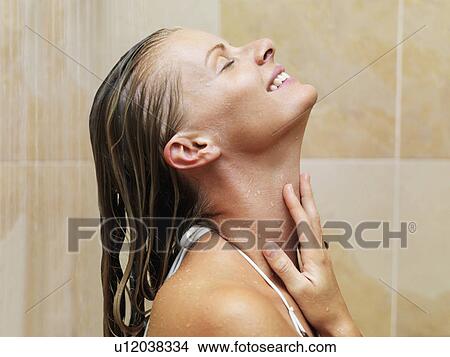 Picture - Mid adult woman in spa shower. Fotosearch
