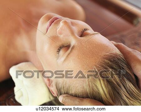 Picture - Mid adult woman receiving head massage. Fotosearch