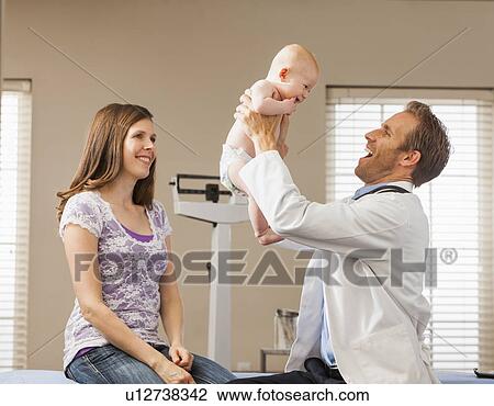 Stock Image - Mother with son (2-5 months) in doctor's office. Fotosearch