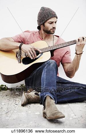 Stock Photograph - Musician playing guitar outdoors. Fotosearch