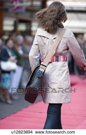 Netherlands, Goirle de Hovel, Young woman walking on city street View Large Photo Image Picture - Netherlands, Goirle de Hovel, Young woman walking on city street. Fotosearch