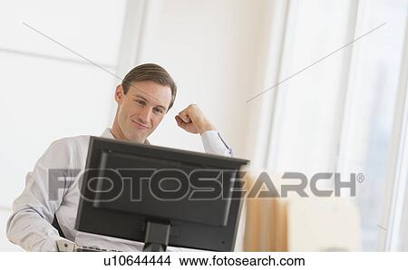 Office worker cheering in front of computer View Large Photo Image Picture - Office worker cheering in front of computer. Fotosearch