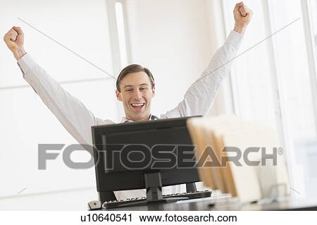 Office worker cheering in front of computer View Large Photo Image Stock Image - Office worker cheering in front of computer. Fotosearch