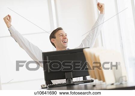 Office worker cheering in front of computer View Large Photo Image Stock Image - Office worker cheering in front of computer. Fotosearch