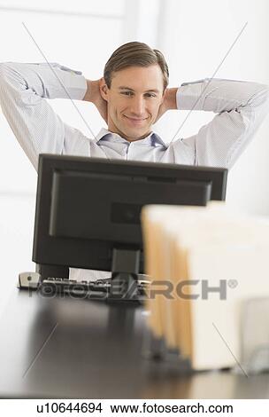 Office worker relaxing in front of computer View Large Photo Image Picture - Office worker relaxing in front of computer. Fotosearch