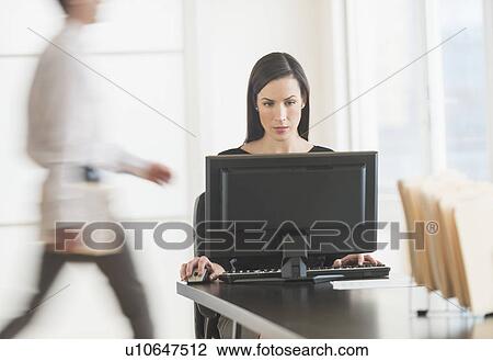 Stock Image - Office worker using computer. Fotosearch